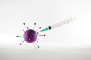 graphic of the virus COVID- and a surgical needed sticking into it