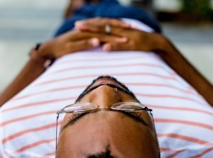person laying down with hands crossed over belly
