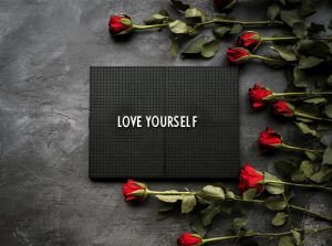 roses with a sign that states love yourself